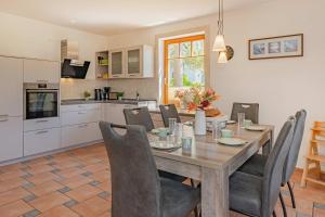 a kitchen and dining room with a wooden table and chairs at Ferienwohnung Wassermann in Loddin