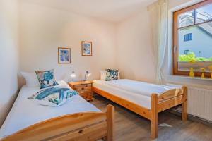 a bedroom with two beds and a window at Ferienwohnung Wassermann in Loddin