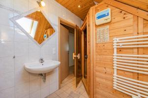 a bathroom with a sink and a wooden wall at Ferienwohnung Wassermann in Loddin +27 photos
