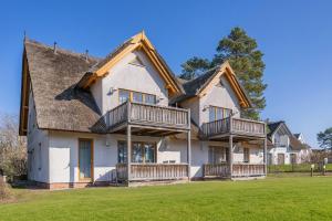 a large house with balconies on a lawn at Ferienwohnung Wassermann in Loddin