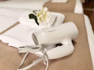 a white hair dryer on a table with a flower at サムティ扇町 in Osaka