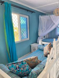 a bedroom with a bunk bed with blue walls at Khangadelic Kilifi in Kilifi