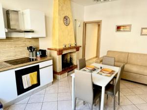 a kitchen and a living room with a table and a couch at Fiorucci Apartments - Daniele's House Lago Di Bolsena in Marta