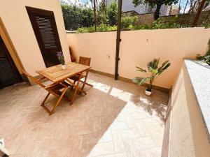 a wooden table and chairs on a patio at Fiorucci Apartments - Daniele's House Lago Di Bolsena in Marta