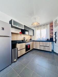 a large kitchen with a refrigerator and a tile floor at L'Escale paisible in Gardanne