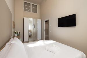 una camera da letto con un letto bianco e una TV a schermo piatto di Casati47 a Magenta