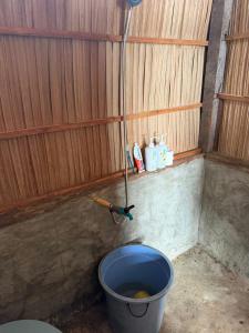 a bathroom with a blue bucket and a toilet at West Waigeo Bungalow in Kabu