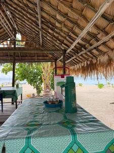 a table on the beach with a green table cloth at West Waigeo Bungalow in Kabu