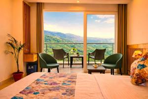 a room with a bed and a large window at The Pine Woods - A Four Star Luxury Resort In Mussoorie Near JW Marriott in Mussoorie