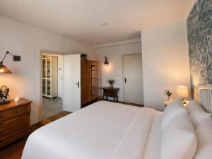 a bedroom with a large white bed and a desk at Finca Ludwig am Forggensee in Rieden