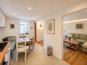 a kitchen and living room with a table and a couch at Finca Ludwig am Forggensee in Rieden