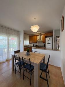 a kitchen and dining room with a wooden table and chairs at Casa Campanilla in Riumar