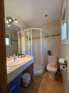 a bathroom with a shower and a sink and a toilet at Casa Campanilla in Riumar +40 photos