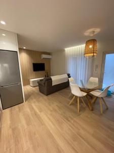 a living room with a couch and a table and chairs at Areias do Norte in Póvoa de Varzim