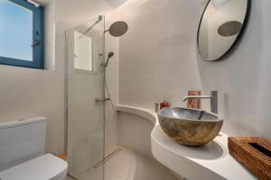 a bathroom with a bowl sink and a mirror at Ikos Kythnos in Kithnos