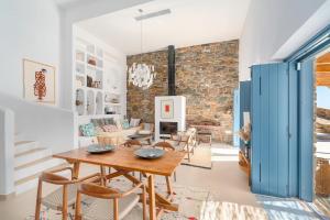 a living room with a table and chairs and a brick wall at Ikos Kythnos in Kithnos