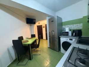 a small kitchen with a table and a refrigerator at Green Paradise in Curtea de Argeş