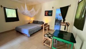 a bedroom with a bed and a desk in it at Lodge Jamarek in Kafountine