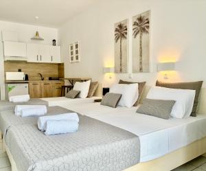 a room with three beds and a kitchen at Thalassa Garden Studios in Pefkochori +33 photos