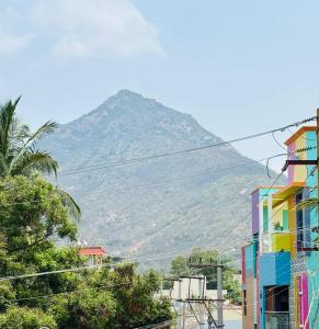 a mountain in the distance with buildings and trees at A2KD Stay - Achyutam Keshavam Krishna Damodaram in Tiruvannāmalai