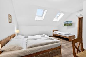 two beds in a room with skylights at Resort Rybníček in Blatnice +58 photos