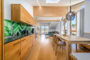 a kitchen with wooden cabinets and a wooden table at Schmuckstück Ferienapartments Bodenmais inkl aktivCARD in Bodenmais