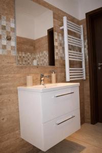 a bathroom with a white sink and a mirror at Sódomb vendégház in Egerszalók +27 photos