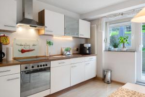 a kitchen with white cabinets and a stove top oven at Fewo Bella in Stegen
