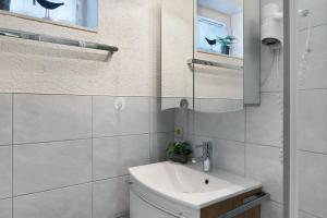 a white bathroom with a sink and a mirror at Fewo Bella in Stegen +29 photos