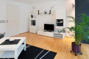 a white living room with a tv and a table at Fewo Bella in Stegen
