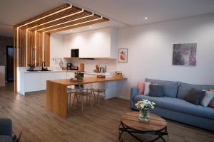 a living room and kitchen with a blue couch at Chez Nous I e II in Caloura