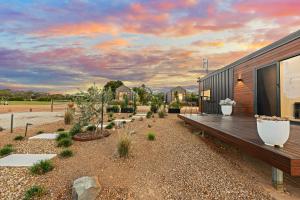 a house with a wooden deck and some plants at Three Ponds Estate in Temora