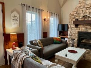 a living room with a couch and a fireplace at Spa & Pool Table - L Experience in Petite-Rivière-Saint-François