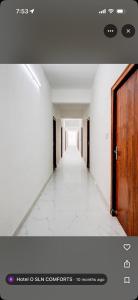a hallway of an empty building with a wooden door at Shivam Elite Comforts in Bangalore