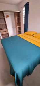 a bedroom with a bed with a yellow and blue blanket at Anse a l ane in Les Trois-Îlets