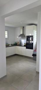 a kitchen with white cabinets and a stove top oven at Anse a l ane in Les Trois-Îlets
