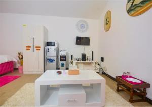 a living room with a white table and a refrigerator at Cutie Studio Unit Nyali in Mombasa +5 photos