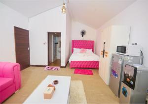 a small room with a bed and a pink couch at Cutie Studio Unit Nyali in Mombasa