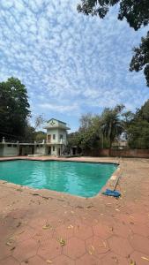 a swimming pool with a house in the background at Gravity Groups SSK - Near Sangamithra Jipmer in Puducherry Airpoert
