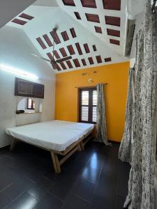 a bedroom with a bed in a room with a ceiling at Gravity Groups SSK - Near Sangamithra Jipmer in Puducherry Airpoert