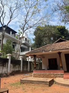 a large white house with a fence in front of it at Gravity Groups SSK - Near Sangamithra Jipmer in Puducherry Airpoert
