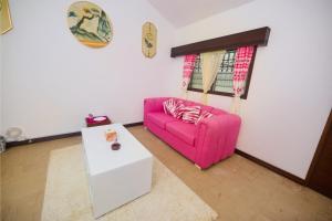 a living room with a pink couch and a table at Cutie Studio Unit Nyali in Mombasa