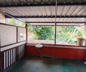 an empty room with a large window in a house at Vikram homestay in Malvan