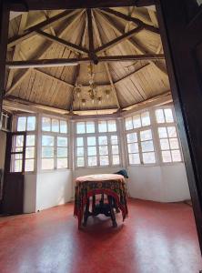 a large room with a table in a room with windows at Vikram homestay in Malvan +2 photos