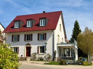 a large white house with a red roof at Schwarzwald Apartments Fürstenberg in Hüfingen