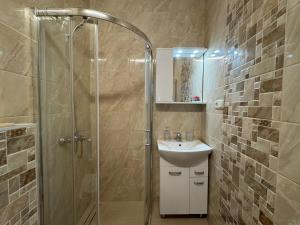 a bathroom with a sink and a glass shower at Po Beržu in Molėtai