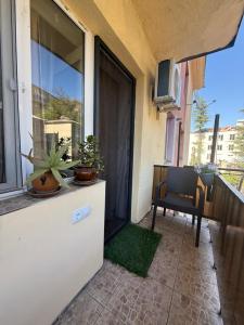 a balcony with a table and a chair and a window at sofia guest house in Chiatʼura