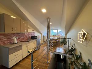 a kitchen with a staircase leading up to a loft at Po Beržu in Molėtai