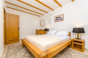 a bedroom with a bed and a wooden door at House Bilusic in Poljica