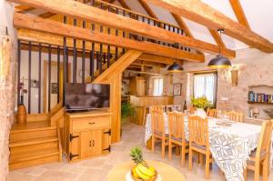 a dining room with a television and a table with chairs at House Bilusic in Poljica